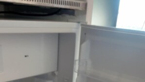 Ein offener Kühlschrank mit übersichtlichen Regalen und einem Gefrierfach.