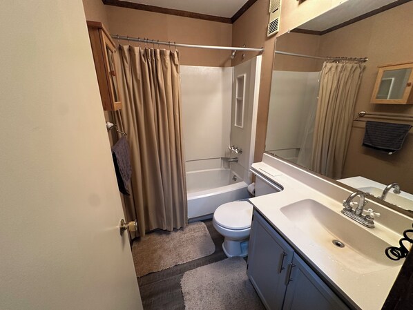 Un baño con bañera, inodoro y lavamanos.