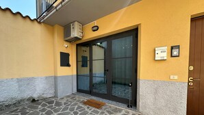 A building entrance with a stone-paved area, a welcome mat, and a door with a glass panel. - Silent Airport Room 5 minutes from BGY airport and Bergamo city center (Azzano San Paolo)