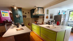 A modern kitchen with green cabinets, a white countertop, and a built-in sink. - Charming country home (Aigurande)