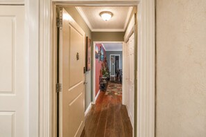 A hallway with a wooden floor, white doors, and a ceiling light. - Modern Designed DTWN Condo with a 99% Walk Score (Atlanta)