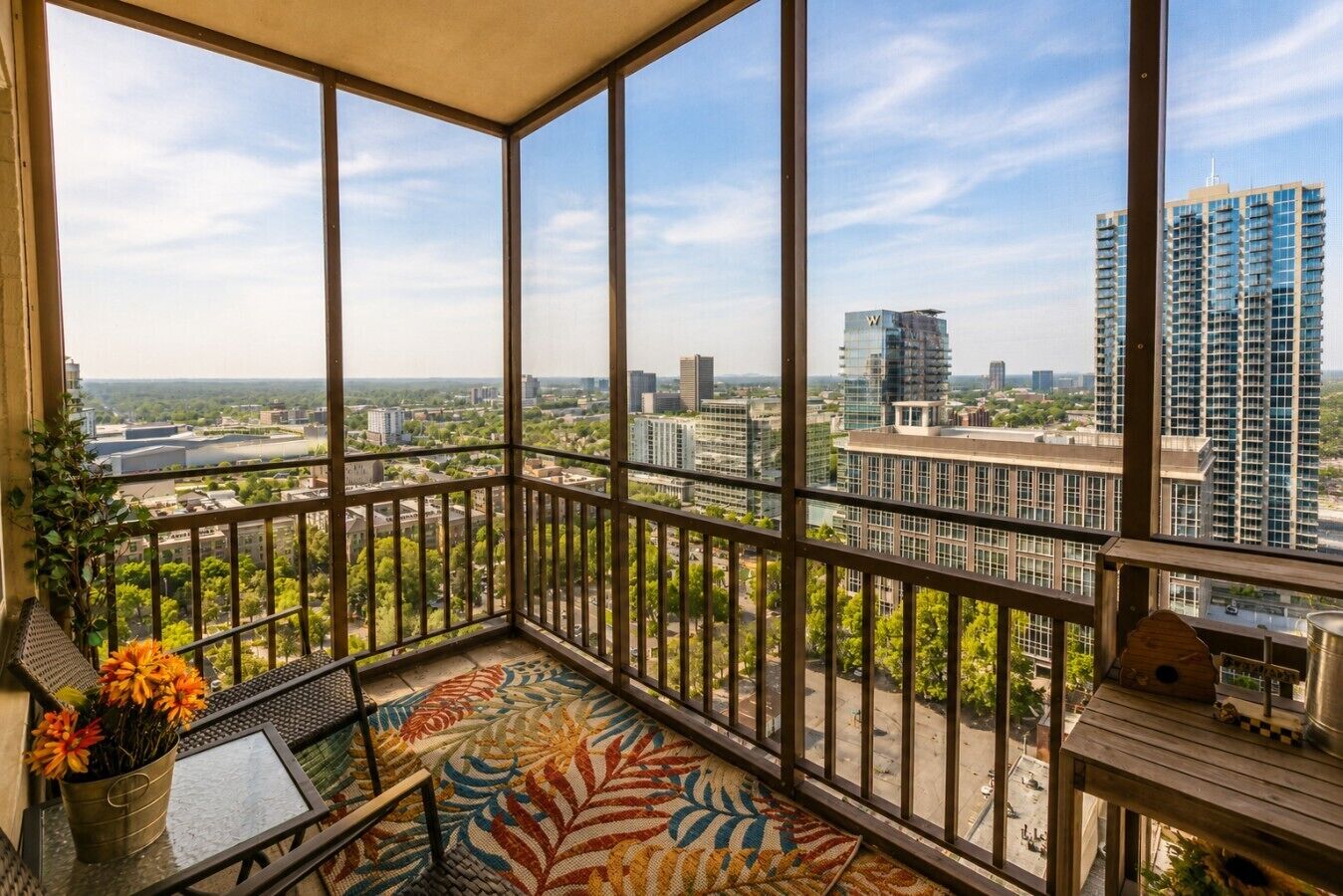 A balcony with a view of a cityscape, including high-rise buildings and greenery.