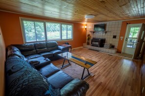 Ein Wohnzimmer mit einer Ledersofa, einem Holztisch und einem Kamin.