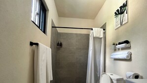 Un baño moderno con ducha, inodoro y perchero para toallas.