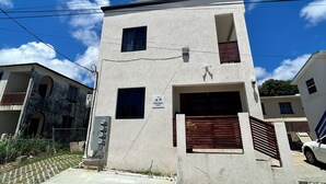 Un edificio de dos plantas con una puerta de garaje, un ventanal pequeño y un letrero que indica un gimnasio.