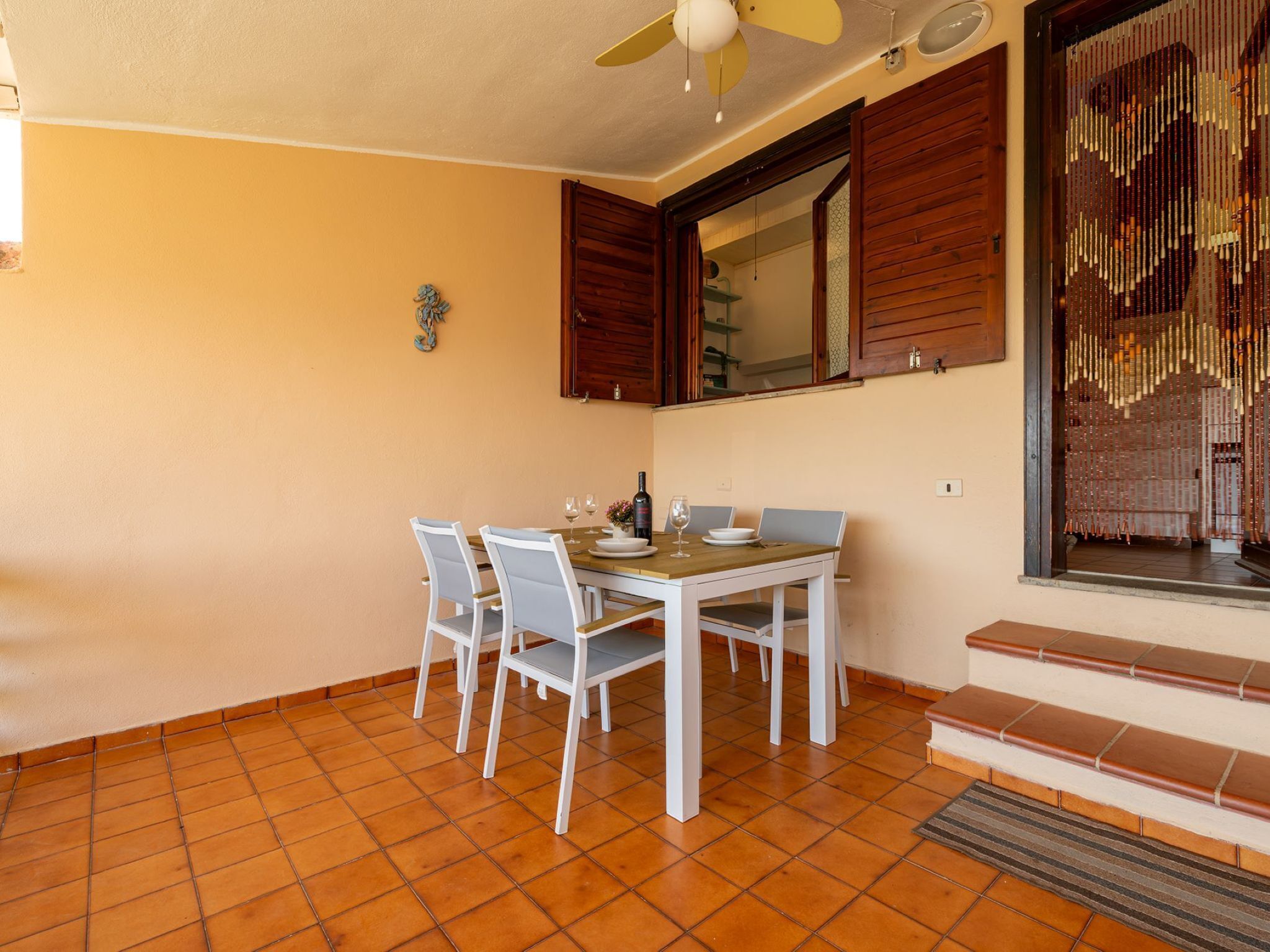 Un comedor con una mesa, sillas y un ventilador de techo.