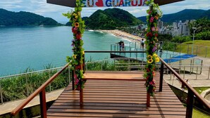 Eine Holztreppe führt zu einer Aussichtsplattform, auf der ein Schild mit der Aufschrift "EU GUARUJÁ" steht.