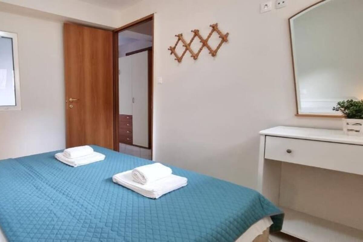 Een hotelkamer met een bed, een bureau, een spiegel en een kledingkast.