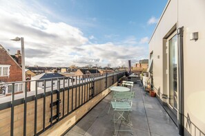 A rooftop terrace with a metal railing, a row of green metal chairs, and a view of surrounding buildings. - Beautiful 1BR, Huge Terrace 17 mins central London - Pass the Keys (Surbiton)