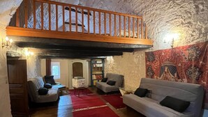 A cozy loft-style living room with a wooden ceiling, a red carpet, and a high wooden balcony. - Lou Castel - Medieval castle (Le Clapier)