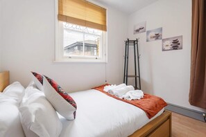 A bedroom with a bed, a window with blinds, a ladder, and wall art. - Stylish 2 BR Flat near Brick Lane, London Sleeps 4 (Greater London)