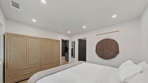 Une chambre à coucher avec un grand lit, une armoire et une décoration murale.