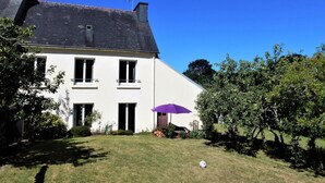 Une maison à deux étages, dotée d’un toit en pente, d’une cheminée et d’une petite antenne parabolique.