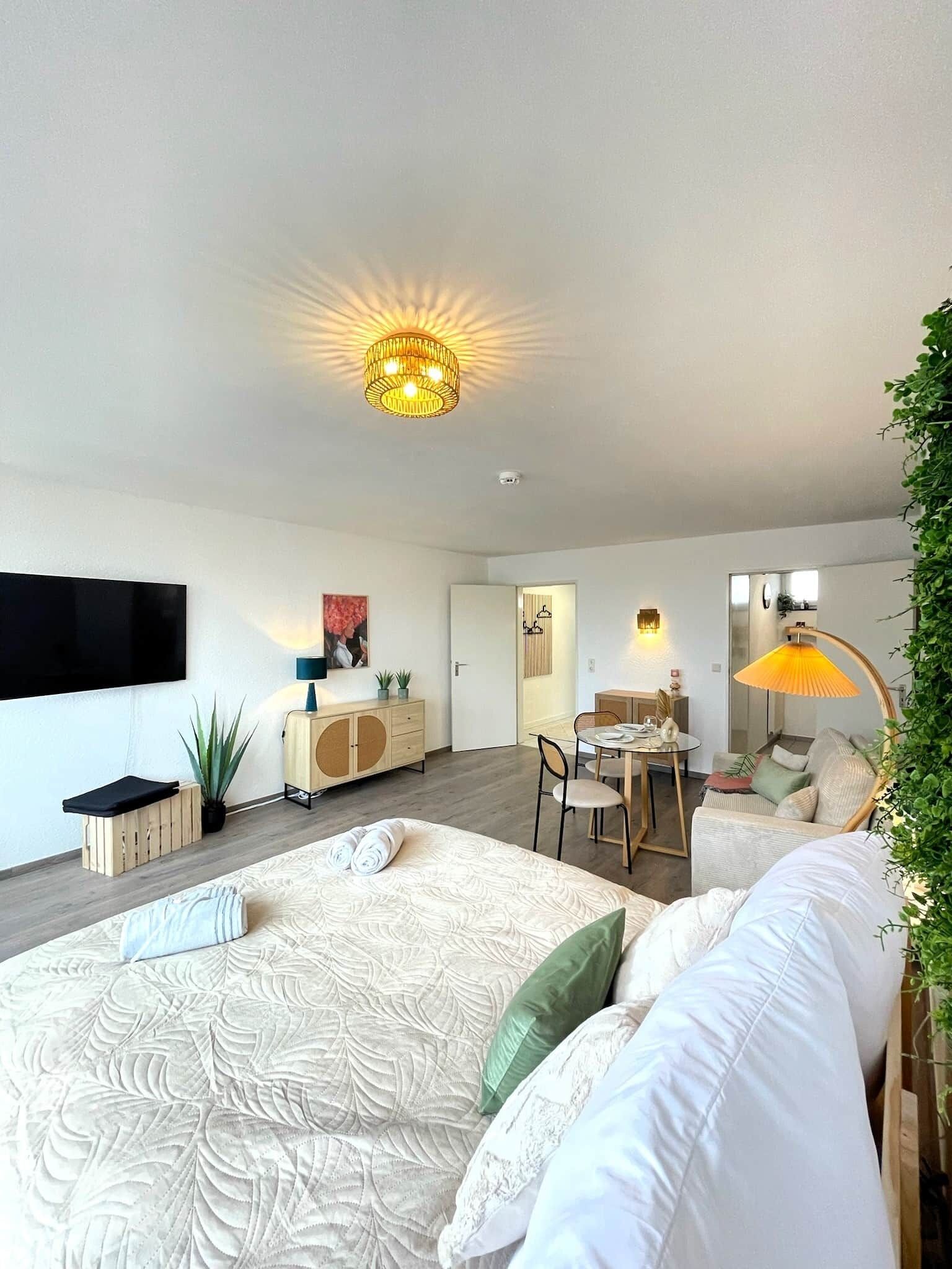 A modern bedroom with a large bed, a dining area, and a living space.