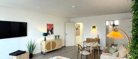 A modern bedroom with a large bed, a dining area, and a living space.