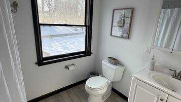 Un baño con inodoro, lavamanos y ventana.
