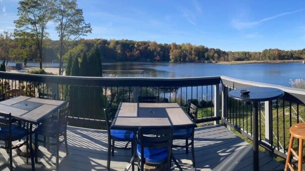 Terraza con mobiliario exterior y vista al lago.