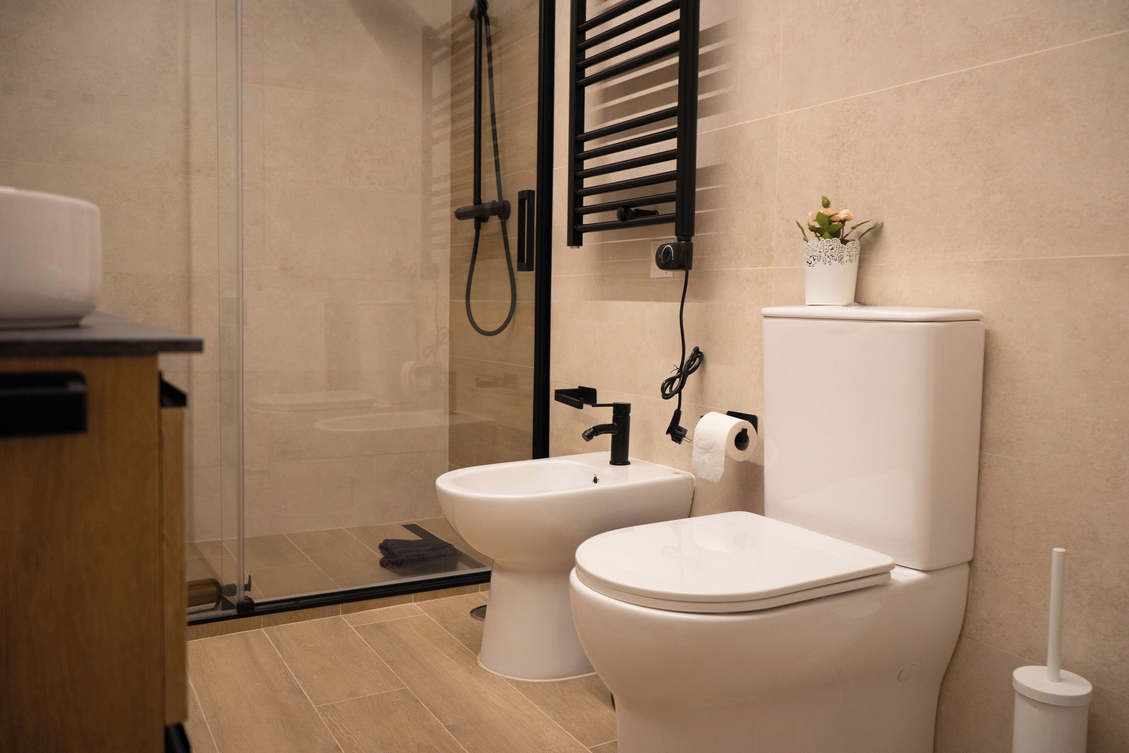 Un baño moderno con cabina de ducha de vidrio, un bidé y un inodoro.