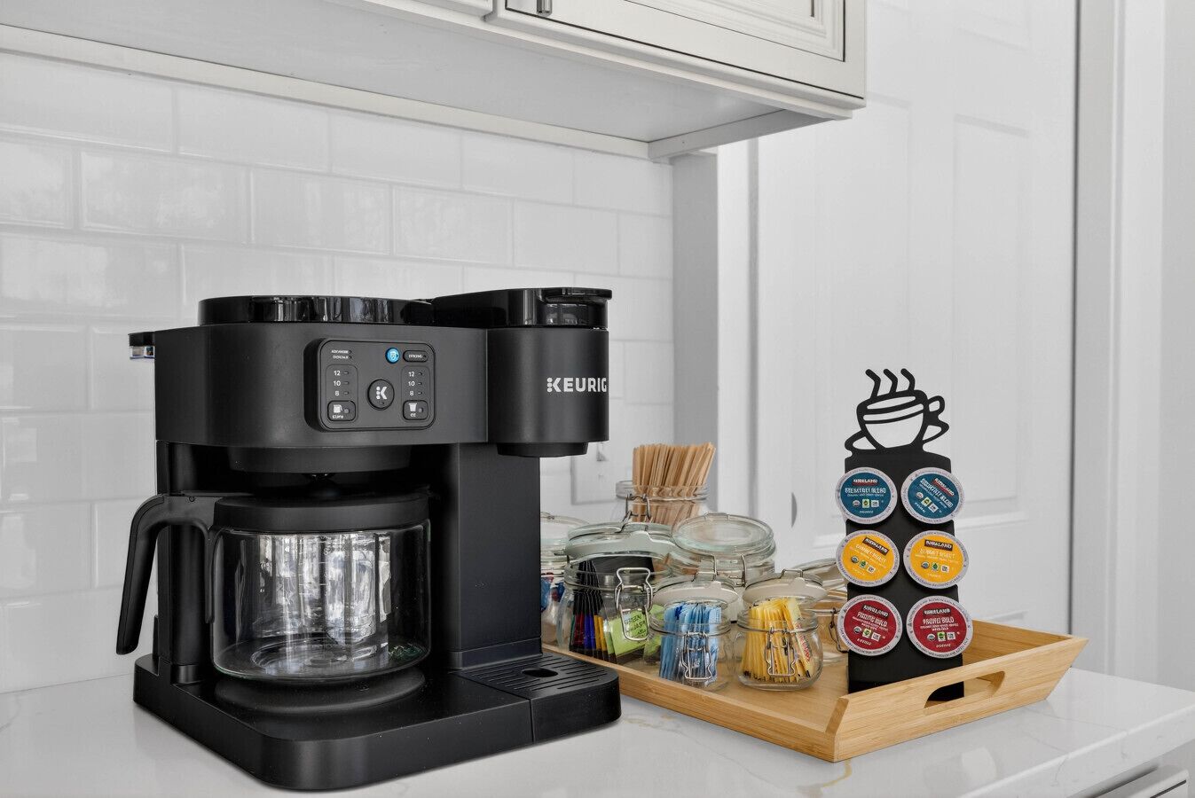 A Keurig coffee maker with a coffee pod holder and a tray of coffee pods.