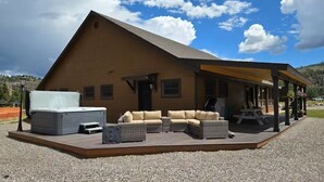 A wooden cabin with a covered patio, outdoor seating, and a hot tub. - Trout Hunter Cabin- South Fork (South Fork)