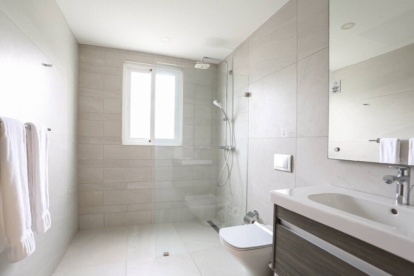 Un baño moderno con ducha, inodoro y lavamanos.