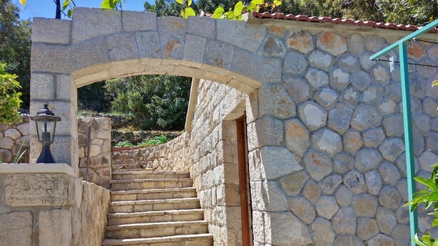A stone staircase leading up to a doorway, surrounded by stone walls and a lantern.