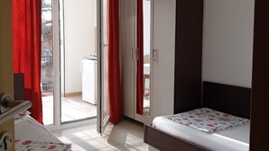 A hotel room with a bed, a desk, and a sliding door leading to a balcony. - Superior Studio Apartment with Sea View and Terrace (Sutomore)