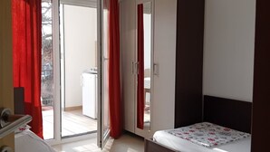 A bedroom with a bed, a wardrobe, and a sliding glass door leading to a balcony. - Superior Studio Apartment with Sea View and Terrace (Sutomore)