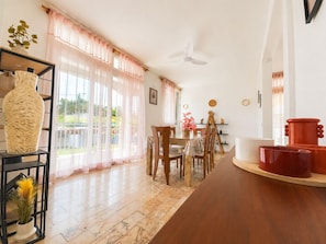 A spacious dining area with a long table, chairs, and a ceiling fan. - Tropical Villa - Comfort and Relaxation (Petit-Bourg)