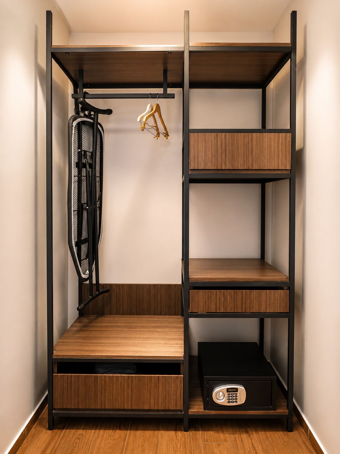 A walk-in closet with multiple wooden shelves, a hanging rack, and a black storage unit.