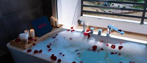 Combined shower/bathtub, hair dryer, slippers, towels