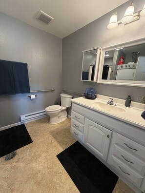 A bathroom with a toilet, sink, and mirror.