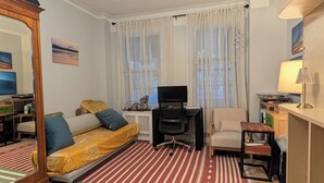 Ett kompakt vardagsrum med en soffa, en fåtölj, en tv och ett litet bord.