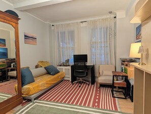 A compact living room with a sofa, a chair, a TV, and a small table. - Large 1-bedroom apartment in beautiful Upper East Side of Manhattan. (New York)