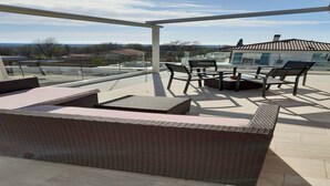 A balcony with wicker furniture, a glass table, and a view of the surrounding area. - Luxury 5 Bed, 7 Bath, Villa. Pool, Gym, Sauna, Hottub, Parking, 2 terr w/Seaview (Jursici)
