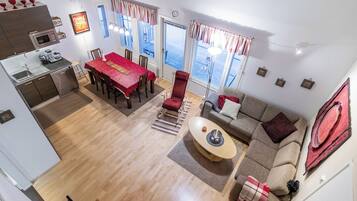 Un appartement moderne comprenant un coin repas, une cuisine, un salon et un balcon avec vue.