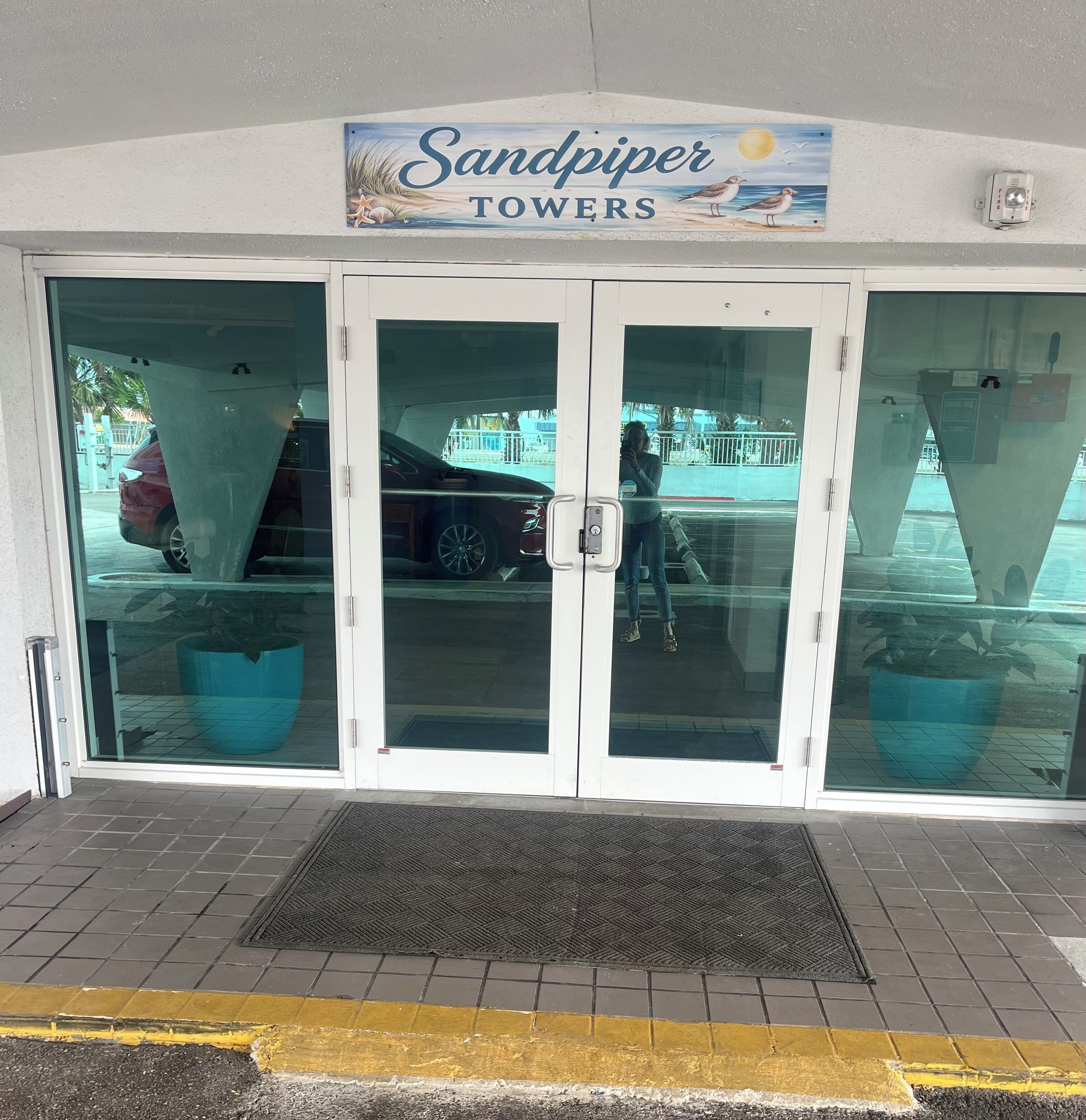 A building entrance with a sign reading "Sandpiper Towers".