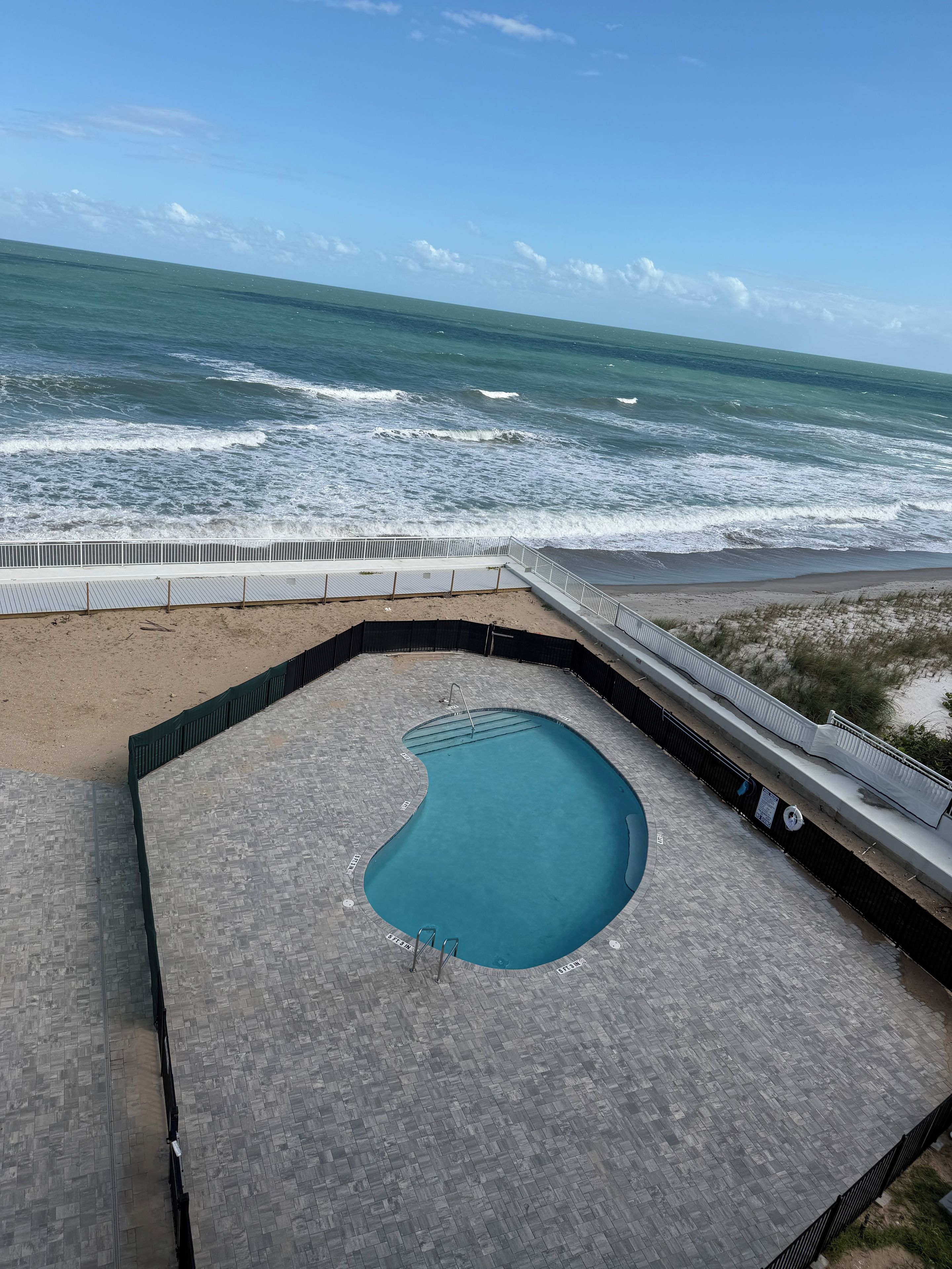 Ein Pool auf dem Dach mit Blick auf den Ozean.