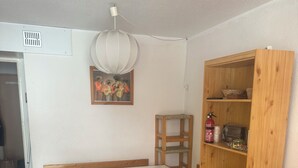 Ein Zimmer mit einem Holztisch, einem braunen Sofa, einem Bücherregal aus Holz und einem Bild an der Wand.
