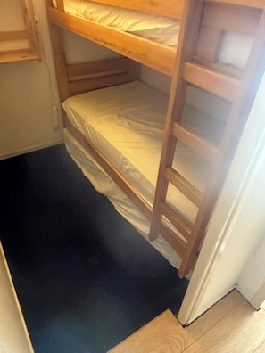 A bunk bed with a ladder, a white wall, and a black floor. - Corbier ski resort, summer and winter vacation rentals (Le Corbier)