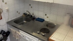 Eine kleine Küche mit einem doppelten Spülbecken, einem Herd und einem Geschirrspüler.