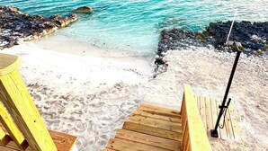 A wooden pier leading to a sandy beach with clear turquoise water. - Pool, Beach, kayaks, great snorkeling, calm side of the island,  (Exuma)
