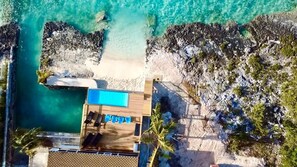 An aerial view of a resort with a swimming pool, lounge chairs, and a beach area. - Pool, Beach, kayaks, great snorkeling, calm side of the island,  (Exuma)