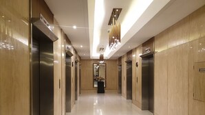 A modern elevator lobby with shiny floors and wooden walls. - SkyLine CtyView Condotel BREEZE RESIDENCES near MOA,NAIA AIRPORT,PICC,US Embassy (Pasay City)
