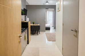 A modern kitchen with a dining area, a small living space, and a view of the city.