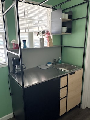 A compact kitchenette with a sink, a coffee maker, and a small countertop. - Welcome to - a private retreat Studio in San Diego. The Rhoades! (San Diego)