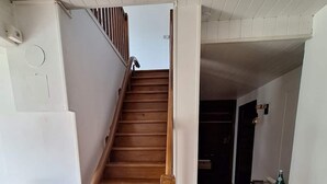 Una escalera de madera con barandilla que conduce a una plataforma.