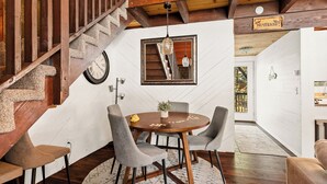 A dining area with a wooden table, grey chairs, and a staircase with a wooden railing. - Stylish & Cozy "Nut House" - Great & Game Room - Spa (Big Bear)