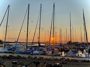 Een jachthaven met verschillende zeilboten bij zonsondergang.
