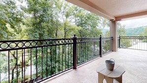 Ein Balkon mit schmiedeeisernem Geländer, einem kleinen Tisch und einem Eimer.